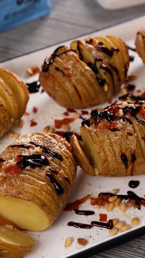 Roasted Hasselback potatoes topped with pine nuts, crumbled prosciutto and a drizzle of balsamic glaze.